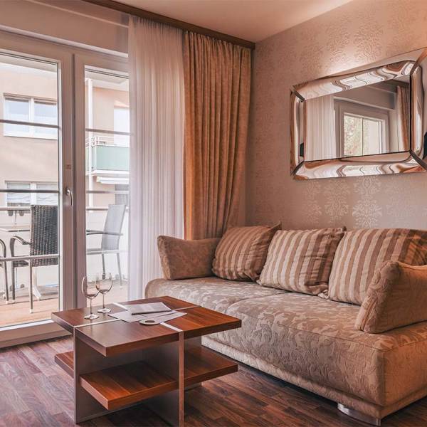 Living area in the apartment at Arkona Strandresidenzen Binz with a cozy sofa, coffee table, and balcony view