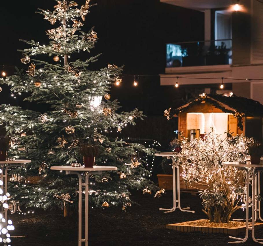 Large decorated Christmas tree with fairy lights in the warmly illuminated outdoor area of a hotel during the Christmas season on Rügen.