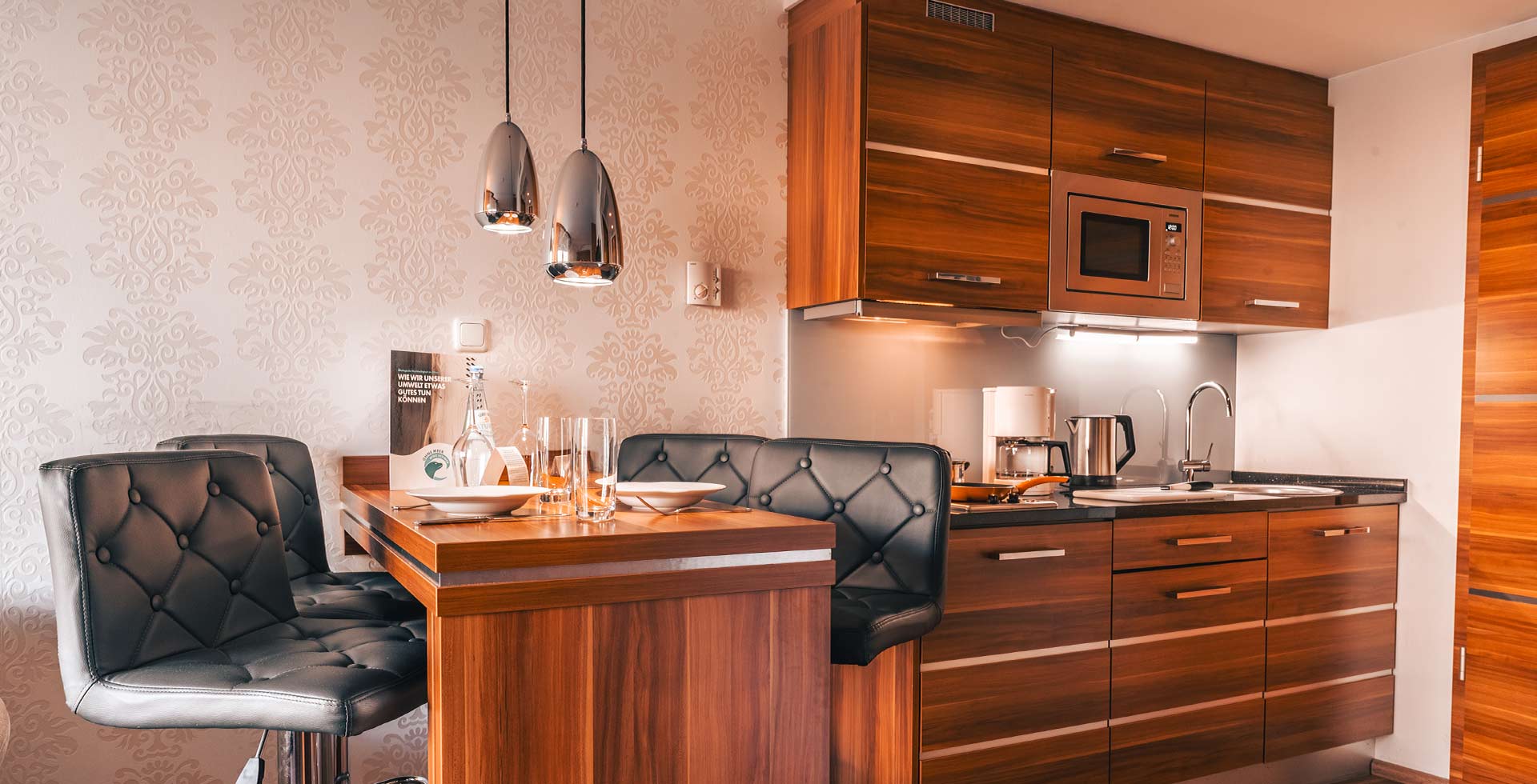 Modern kitchenette with dining area in the apartment at Arkona Strandresidenzen Rügen – perfect for self-catering